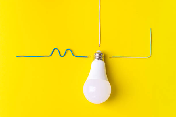 istock Led light bulb with connected wire phase, zero, ground on a yellow background. New technology of energy, Eco power concept. Copy space. Power saving concept. 1288472965