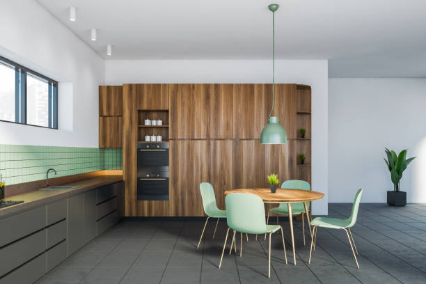 istock Modern gray and wooden kitchen with dining table 1288475594