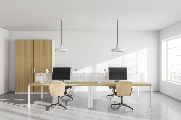 istock Modern white open space office interior with wooden tables and wardrobe 1288476938