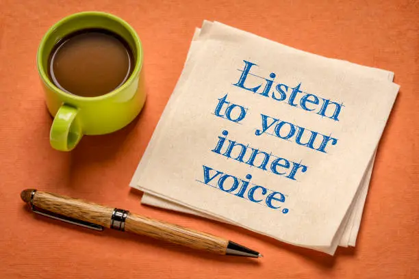 listen to your inner voice - inspirational handwriting on a napkin with a cup of coffee, confidence, intuition and personal development concept