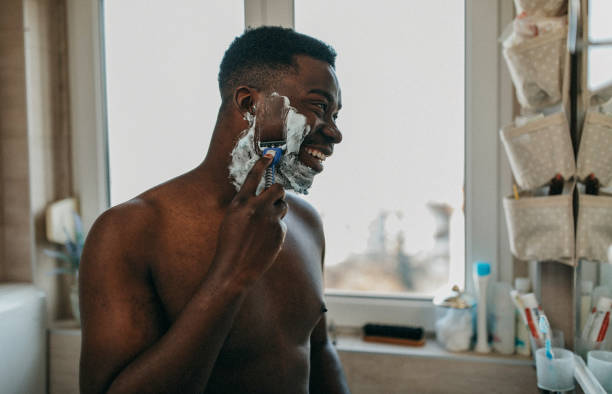 młody człowiek robi poranne rytuały - men shaving human face bathroom zdjęcia i obrazy z banku zdjęć