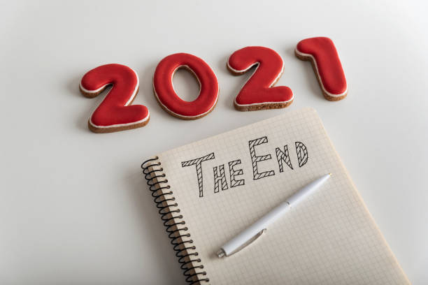 istock Number 2021, pen and notebook with THE END inscription close up. White background. 1288481324