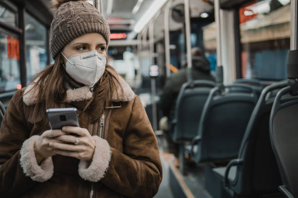 istock A woman with a face mask is using mobile phone on public transportation 1288484054