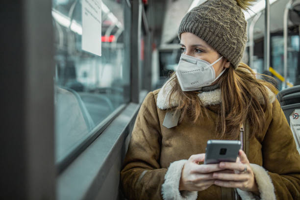 istock A woman with a face mask is using mobile phone on public transportation 1288484077