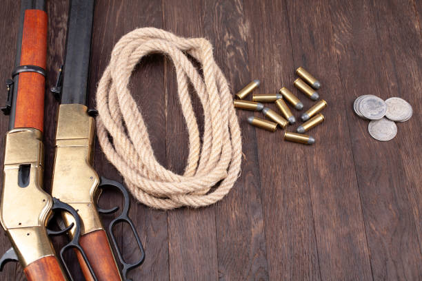 istock Wild west gun - lever-action repeating rifle with ammunition and silver dollar coins 1288485786