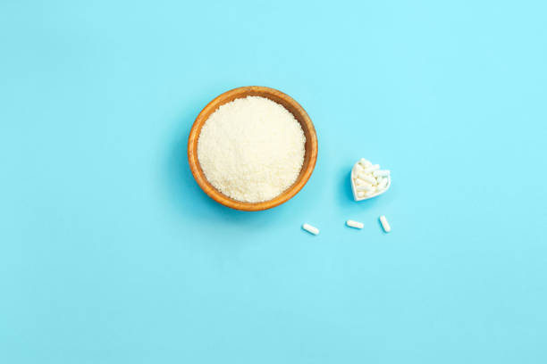 istock Collagen powder and pills on blue background. 1288487486