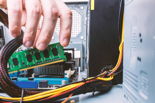 istock male person or technician worker installing ddr ram memory module to a desktop pc case. close up. looking inside computer case. appliance service concept 1288493832