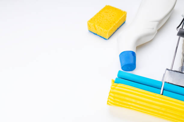 istock clean concept. set of tools for housework cleaning over orange background. cleaning sponge, sponge mop. copy space. above view 1288493979