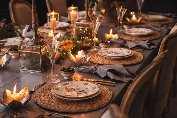 Christmas table with candles, flowers and glass cups.