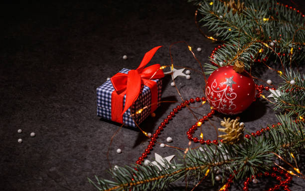 istock Background or preparation for a postcard. Christmas tree branches and decorations on a dark background. A Christmas present. 1288498153
