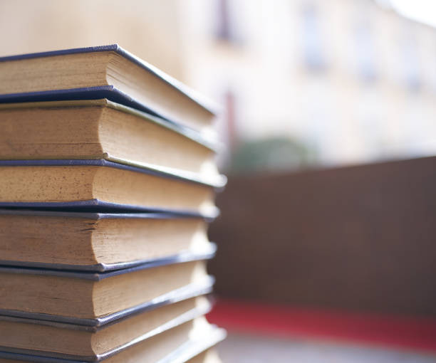 istock several old and slightly worn books stacked in a tower on a desk 1288500015