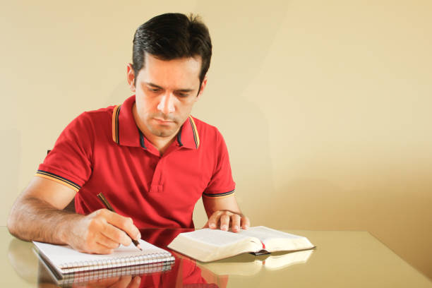 istock Man reading the bible and writing notes on a paper 1288502020