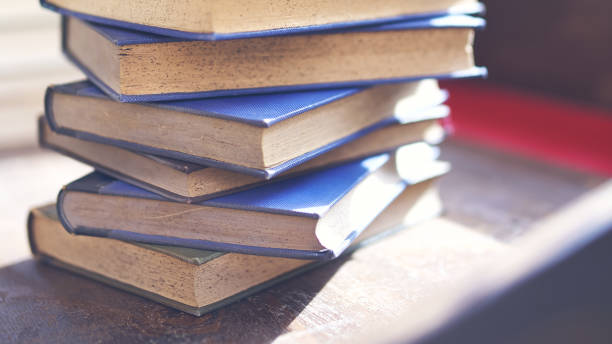 istock several old and slightly worn books stacked in a tower on a desk 1288502160