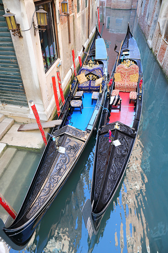 Gondolier rowing gondola on scenic canal in Venice, Italy.