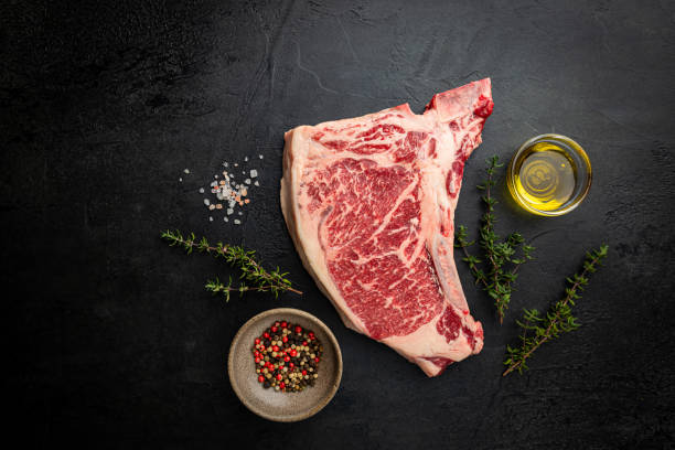Raw Beef Steak Raw fresh meat T-bone beef Steak on black background, top view t bone steak stock pictures, royalty-free photos & images