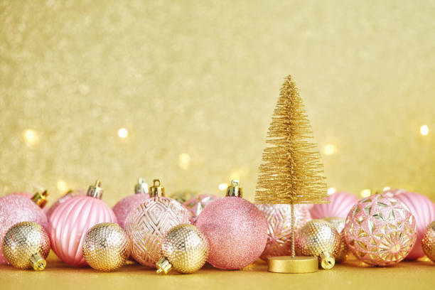 istock Glittering Christmas Background with Pink and Gold Decorations and Christmas Tree 1288521639