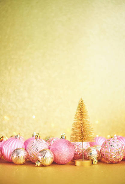 istock Glittering Christmas Background with Pink and Gold Decorations and Christmas Tree 1288521881