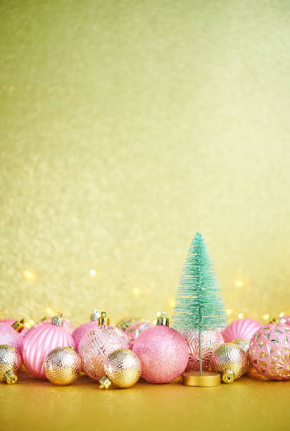 istock Glittering Christmas Background with Pink and Gold Decorations and Christmas Tree 1288521884