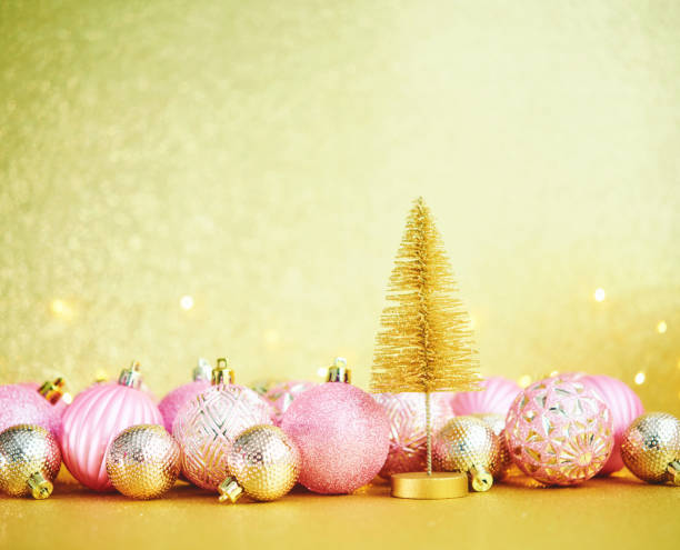 istock Glittering Christmas Background with Pink and Gold Decorations and Christmas Tree 1288521894