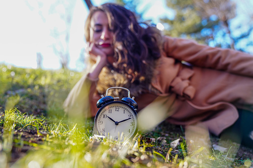 a woman with an alarm clock in the park