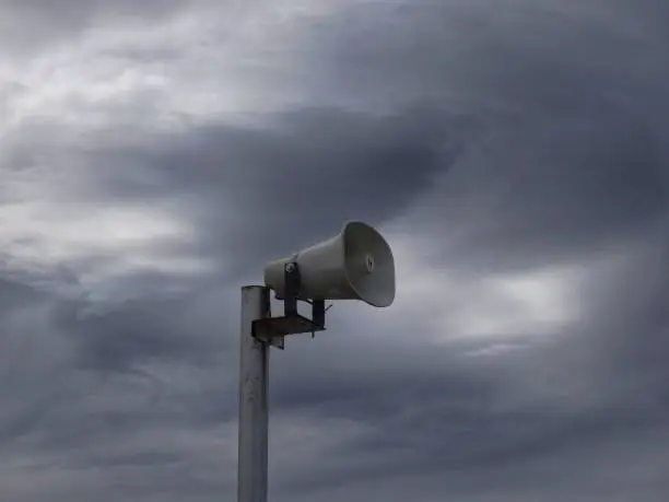 Tornado siren against a backdrop of dark clouds