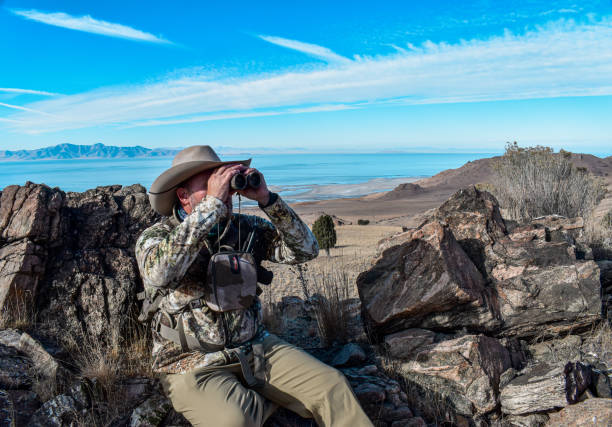 istock Hunter man in camo with cowboy hat camo and pistol binoculars 1288531388