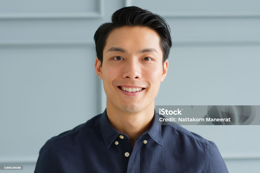 Portrait young confident smart Asian businessman look at camera and smile Men Stock Photo