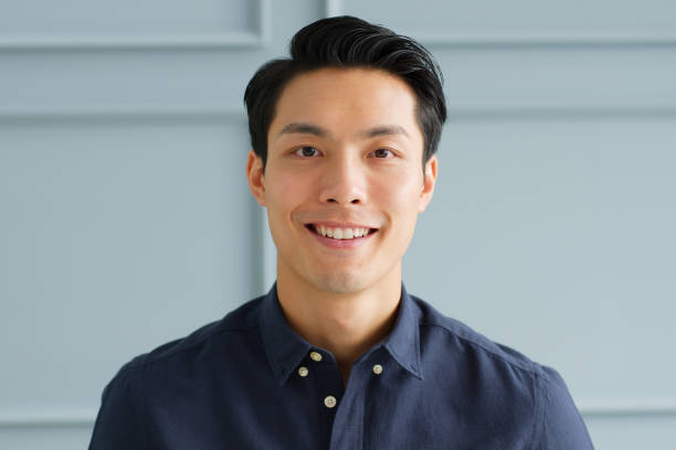 Portrait young confident smart Asian businessman look at camera and smile Portrait young confident smart Asian businessman look at camera and smile looking at camera photos stock pictures, royalty-free photos & images