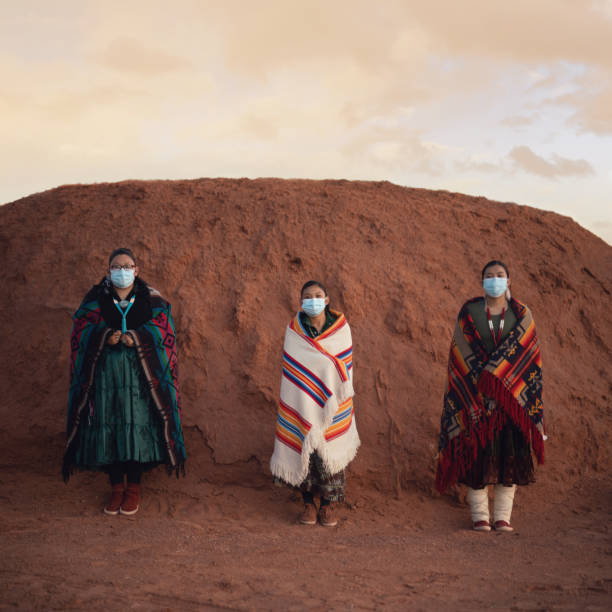 Three young sisters wearing masks in front of a Navajo hogan during covid-19 Three young sisters wearing masks in front of a Navajo hogan during covid-19 navajo nation covid stock pictures, royalty-free photos & images