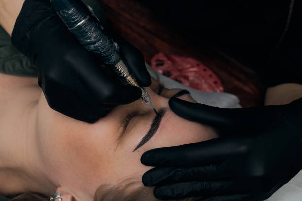 istock Permanent eyebrow makeup procedure. Eyebrow tattooing, process. The use of tools by a master for permanent eyebrow makeup. 1288543710