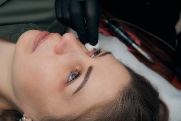 istock Permanent eyebrow makeup procedure. Eyebrow tattooing, process. The use of tools by a master for permanent eyebrow makeup. 1288543732