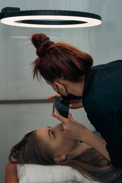 Permanent eyebrow makeup procedure. Eyebrow tattooing, process. The use of tools by a master for permanent eyebrow makeup.