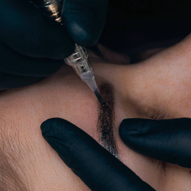 istock Permanent eyebrow makeup procedure. Eyebrow tattooing, process. The use of tools by a master for permanent eyebrow makeup. 1288543759