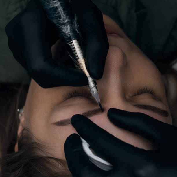 istock Permanent eyebrow makeup procedure. Eyebrow tattooing, process. The use of tools by a master for permanent eyebrow makeup. 1288543771