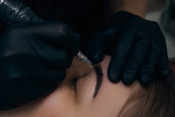 istock Permanent eyebrow makeup procedure. Eyebrow tattooing, process. The use of tools by a master for permanent eyebrow makeup. 1288543774