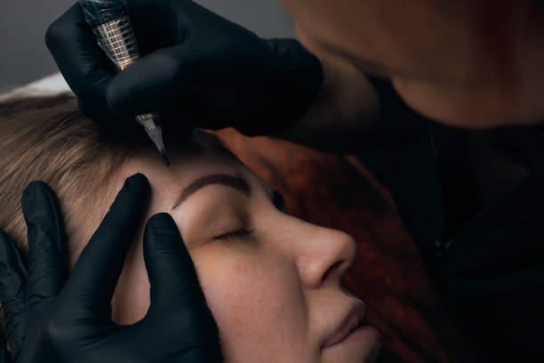 istock Permanent eyebrow makeup procedure. Eyebrow tattooing, process. The use of tools by a master for permanent eyebrow makeup. 1288543783