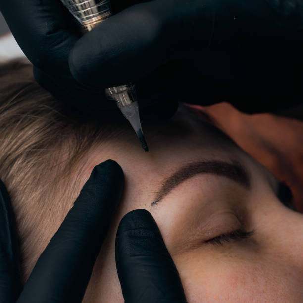istock Permanent eyebrow makeup procedure. Eyebrow tattooing, process. The use of tools by a master for permanent eyebrow makeup. 1288543784