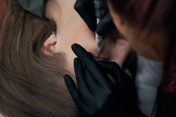 istock Permanent eyebrow makeup procedure. Eyebrow tattooing, process. The use of tools by a master for permanent eyebrow makeup. 1288543803