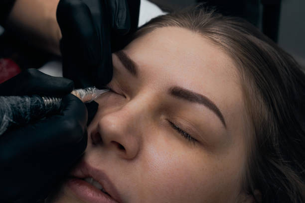 istock Permanent eyebrow makeup procedure. Eyebrow tattooing, process. The use of tools by a master for permanent eyebrow makeup. 1288543890