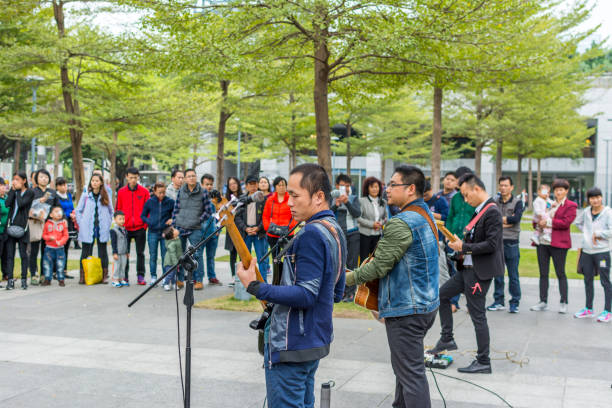 due uomini della band locale di shenzhen che suonano la chitarra e cantano al parco centrale di shenhzhen. - popular music concert outdoors central park people foto e immagini stock