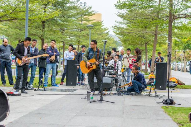 due uomini della band locale di shenzhen che suonano la chitarra e cantano al parco centrale di shenhzhen. - popular music concert outdoors central park people foto e immagini stock