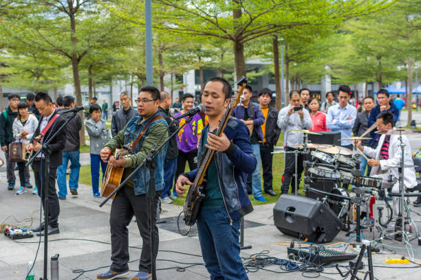двое мужчин шэньчжэньской местной уличной группы palying гитары и петь в центральном парке shenhzhen. - popular music concert outdoors central park people стоковые фото и изображения