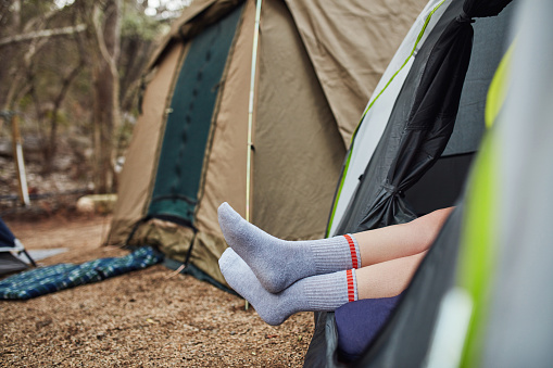 Shot of an unrecognisable man relaxing in a tent out in nature