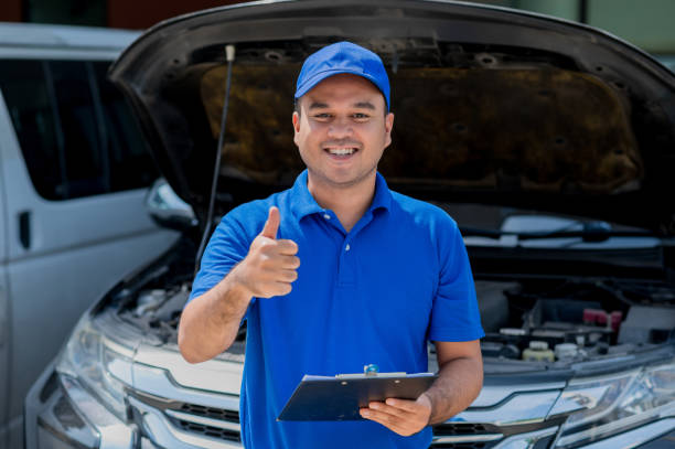 istock A young Asian auto mechanic opens the bonnet. To check for engine damage And perform professional maintenance. He wearing blue uniform. 1288555885