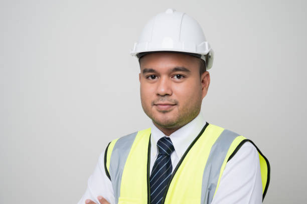 istock Smiling young asian civil engineer wearing helmet hard hat standing on isolated white background. Mechanic service concept. 1288556922