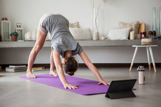 donna che fa yoga al chiuso - yoga business women living room foto e immagini stock