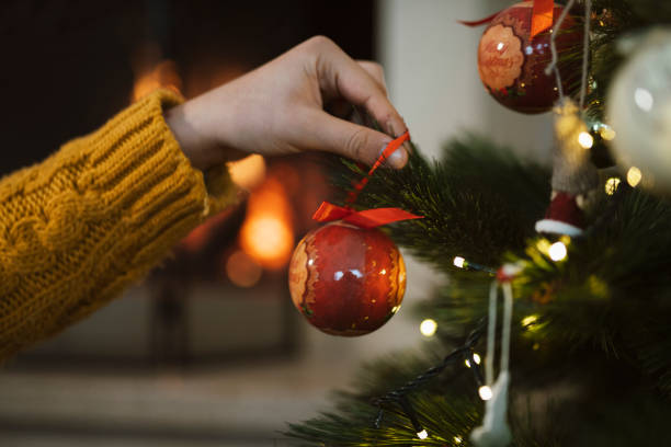 istock Woman decorating Christmas tree. 1288561239