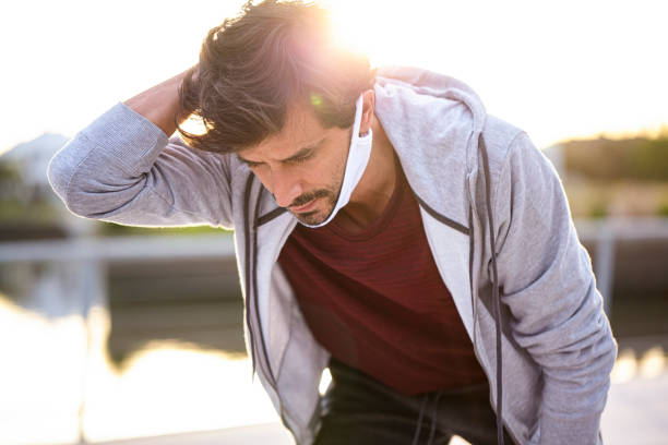 istock Man holding neck outdoors 1288561304