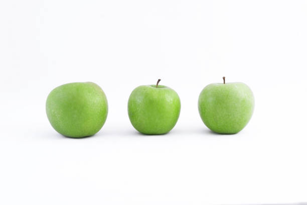 istock Three fresh sour healthy green apples on a white background 1288561323