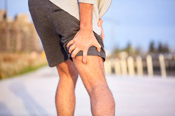 istock Man holding injured leg 1288561325